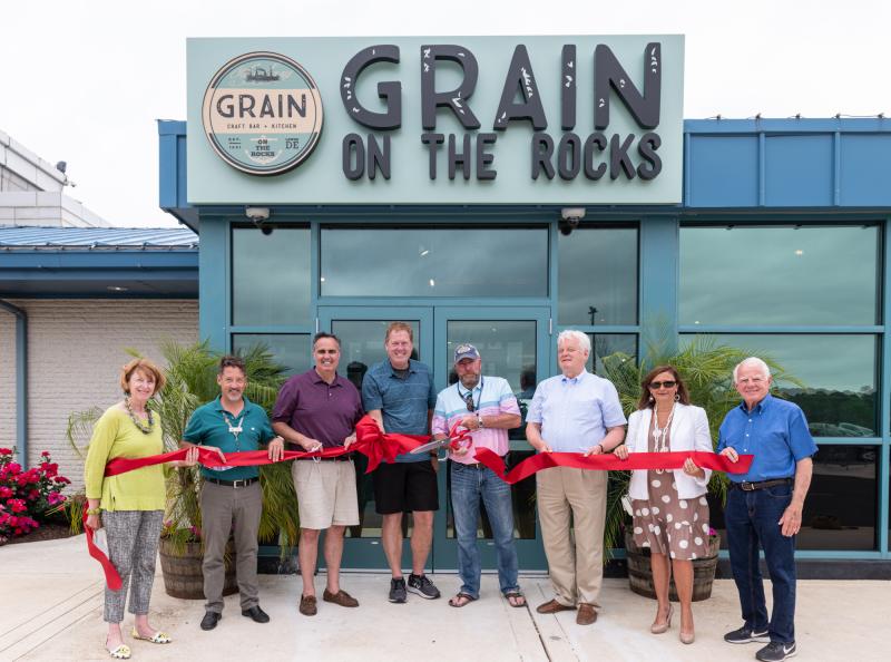The Lewes Chamber of Commerce held a ribbon-cutting ceremony June 12. Shown are (l-r) Betsy Reamer, Lewes Chamber executive director; Heath Gehrke, director of ferry operations; Sen. Ernie Lopez, R-Lewes; Lee Mikles, Grain co-owner; Jim O’Donoghue, Grain co-owner; Ted Becker, Lewes mayor; Nikky Fisher, Lewes Chamber board president; and Dennis Reardon, Lewes City Council. Participants briefly took off face coverings for the photograph. SUBMITTED PHOTO